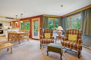 Relax in this inviting living area with a large window offering a view of the outdoors, a dining table, sofa, and comfortable seating.