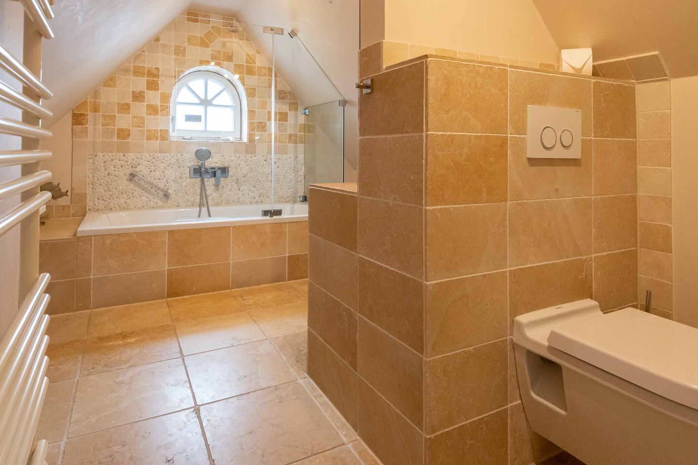 A bathroom with a bathtub, a toilet, and a shower area.