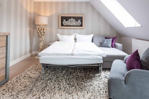 Un dormitorio con cama, sofá, lámpara y un adorno en la pared.