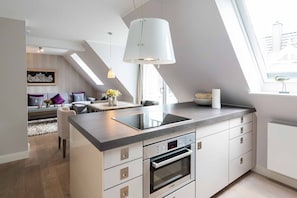 Una cocina moderna con estufa integrada, horno y un amplio ventanal para luz natural.