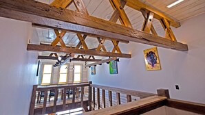 A wooden staircase with a view of the dining area below.