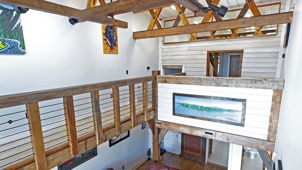 A spacious living area with a wooden ceiling, a large flat-screen TV, and a sectional sofa.