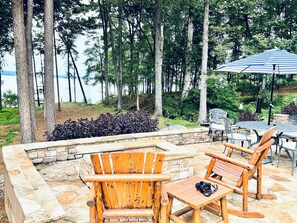 A patio area with wooden Adirondack chairs, a table, and a camera on the table.