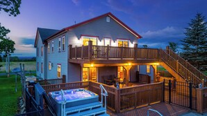 A two-story house with a hot tub, outdoor seating, and a deck. - Spacious 9BR Family Retreat w/Indoor Heated Pool! (Amsterdam)