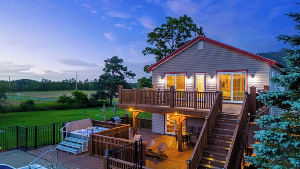 A two-story house with a deck, outdoor seating, and a swimming pool. - Spacious 9BR Family Retreat w/Indoor Heated Pool! (Amsterdam)