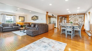 A spacious living area with a sofa, a coffee table, and a dining table with chairs. - Spacious 9BR Family Retreat w/Indoor Heated Pool! (Amsterdam)