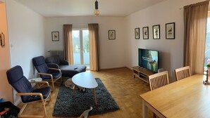 A living room with a TV, seating, and a view of the outdoors. - 4 Bed Apartment with balcony in Karlskrona (Karlskrona)