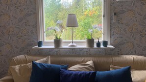 A room with a window, a sofa, and a lamp.