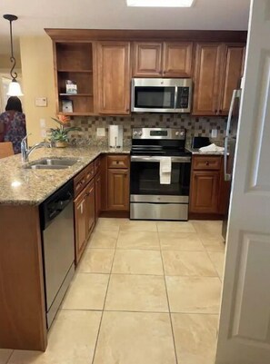 Enjoy cooking in this well-equipped kitchen with a central island, dishwasher, microwave, and double oven.