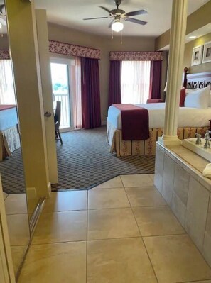 Relax in this traditional room with a single bed, ceiling fan, and large window.