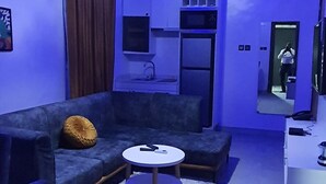 A modern living room with a sofa, a round coffee table, and a ceiling light. - Sapphire Residences by Crystal (Lagos)