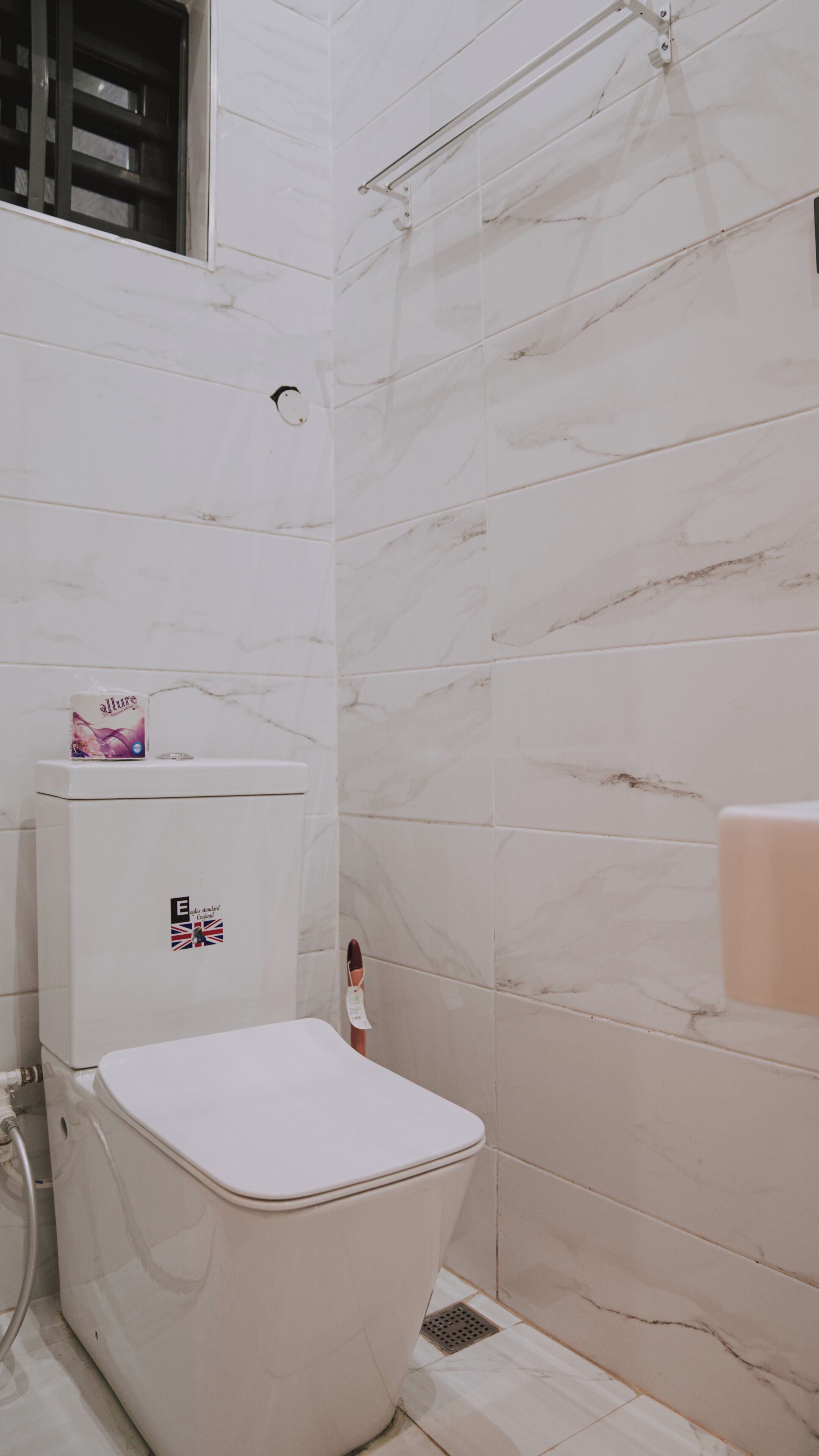 Een badkamer met toilet, douche en wastafel.
