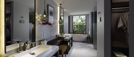 A modern bathroom with dual sinks, a large mirror, and a bathtub.