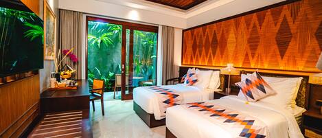 A hotel room with two beds, a TV, a wooden ceiling, and a view of greenery outside.