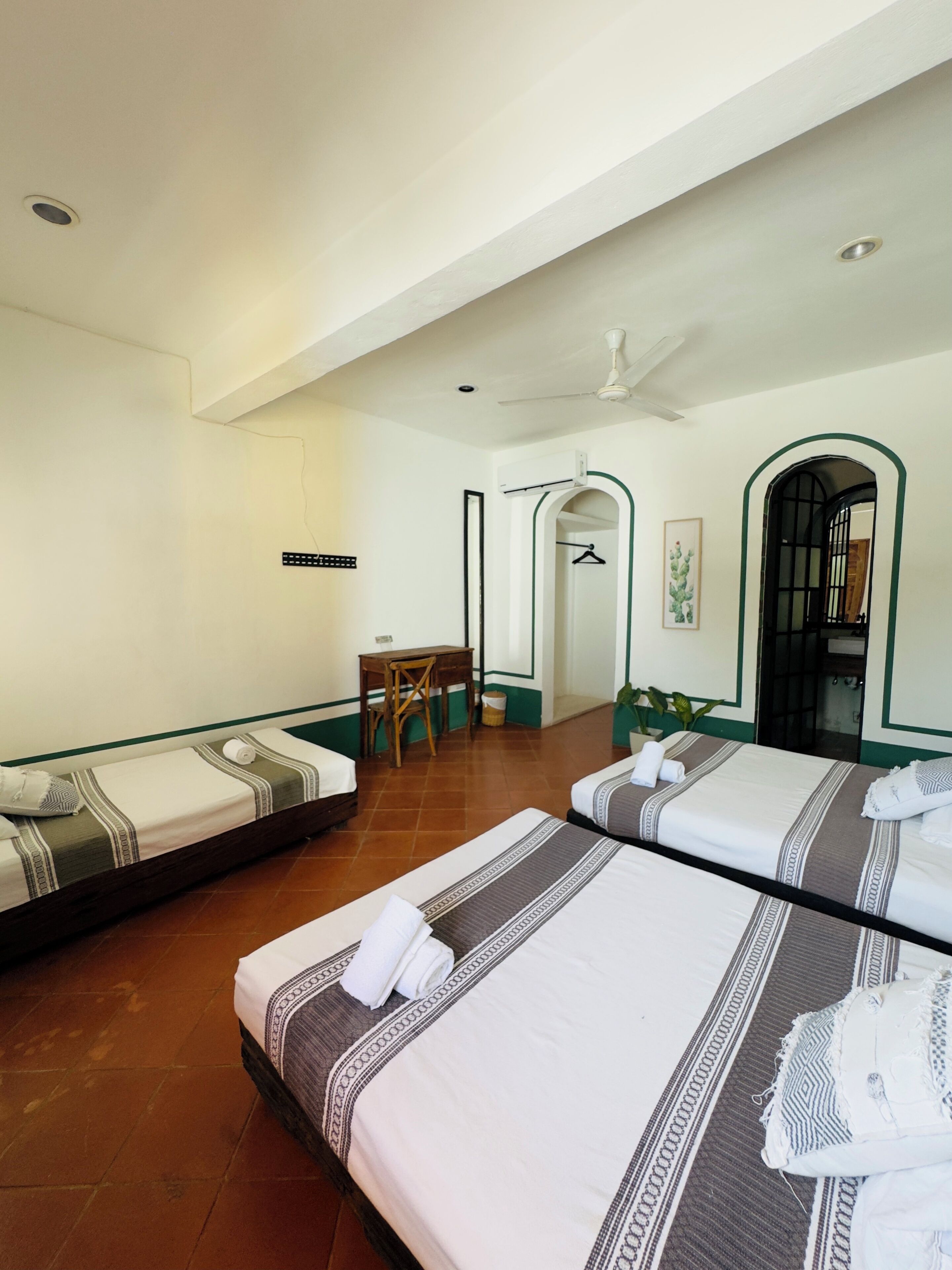 A hotel room with two beds, a small table, and a chair.