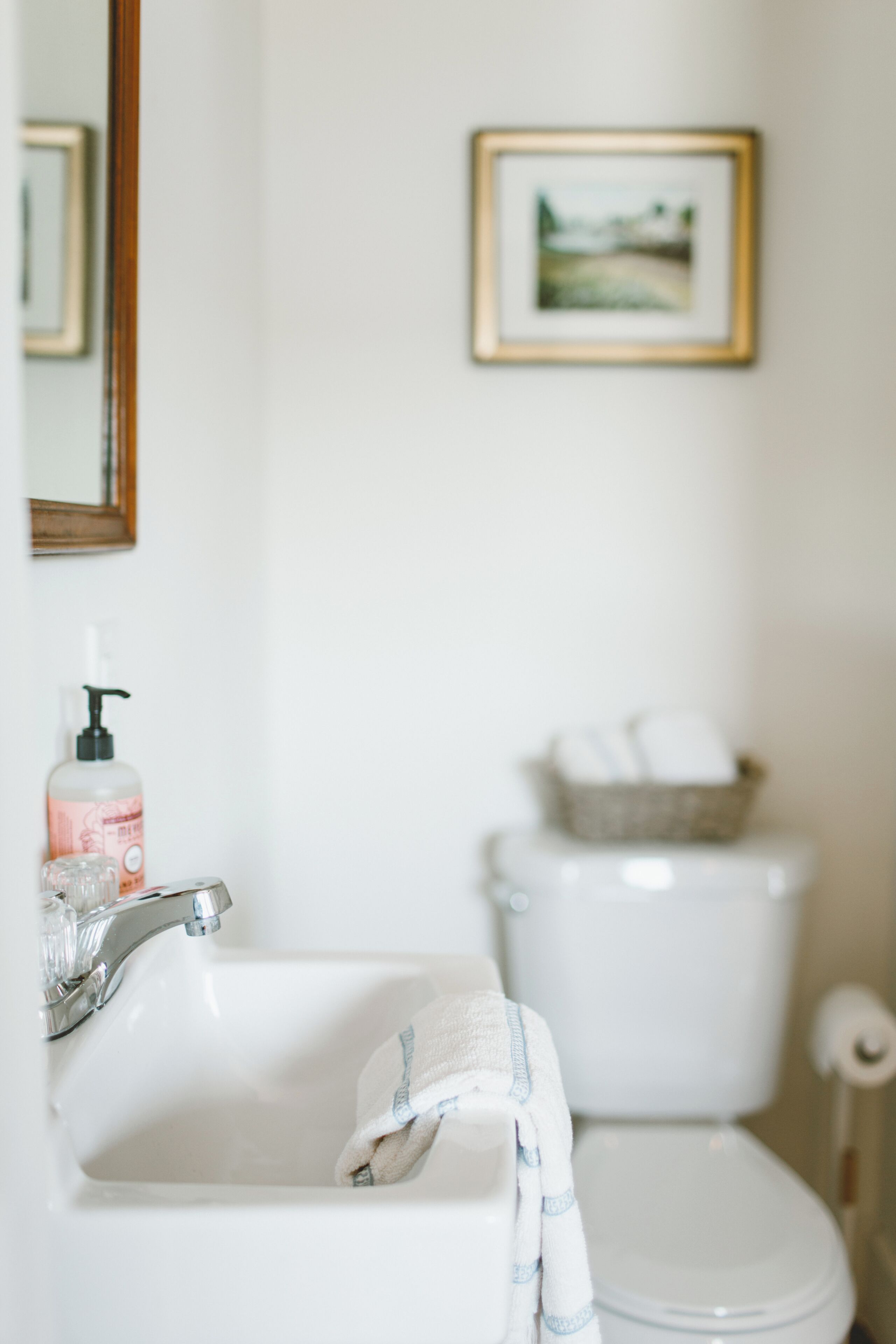 Une salle de bain avec un lavabo, des toilettes et un tableau encadré au mur.
