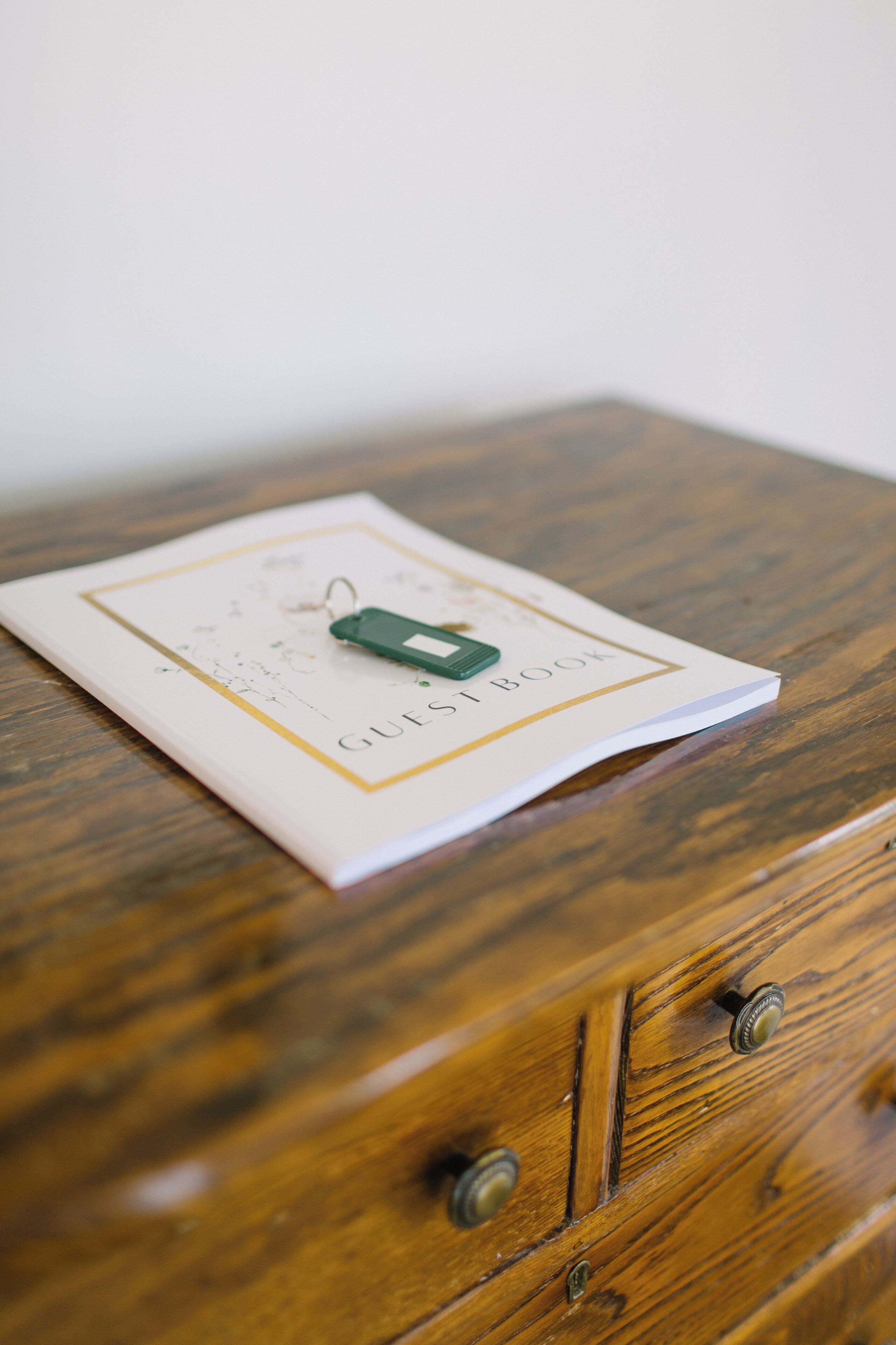 A book titled "GUESS BOOK" on a wooden surface.
