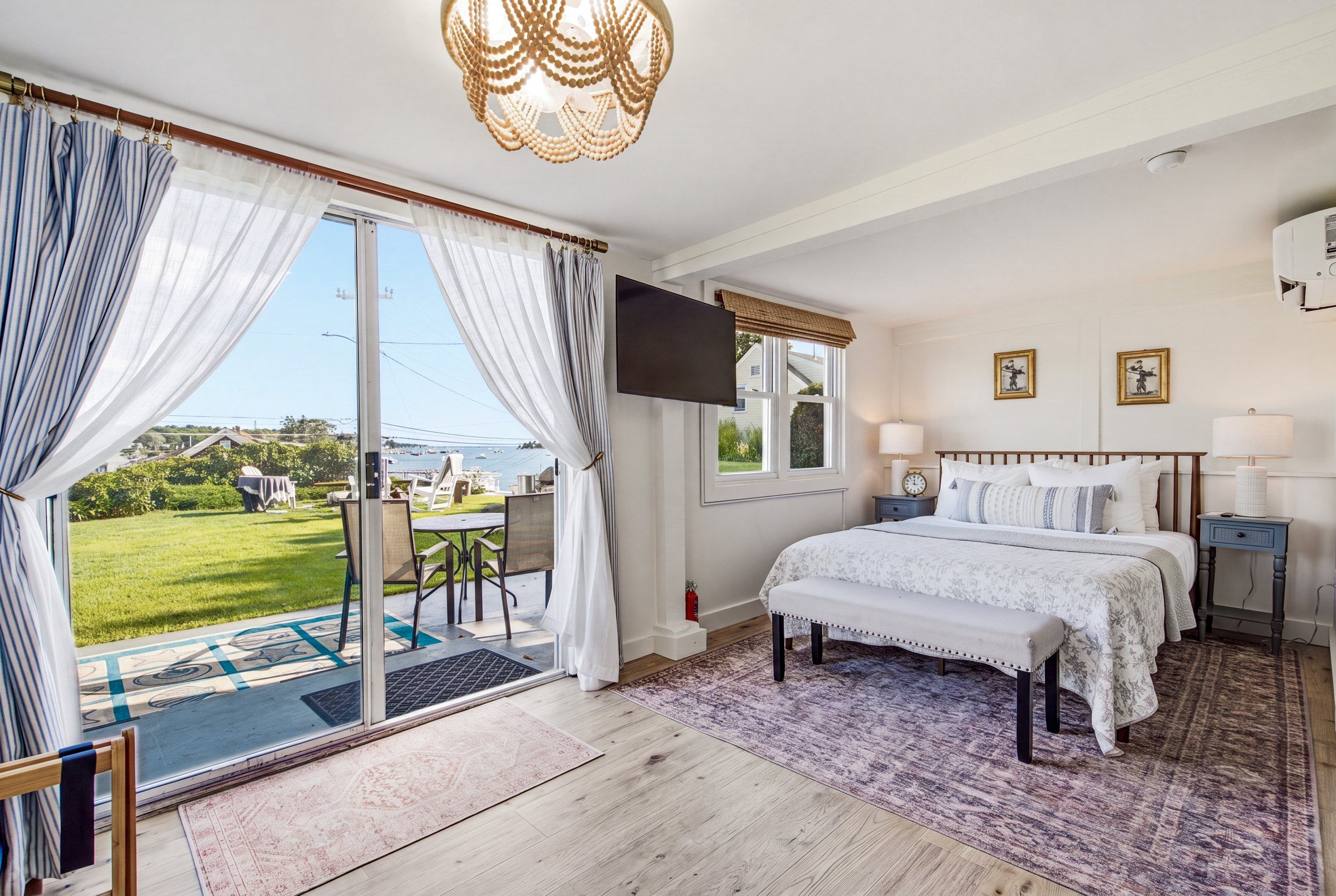 Un dormitorio con cama, televisor, ventana y vistas al exterior.
