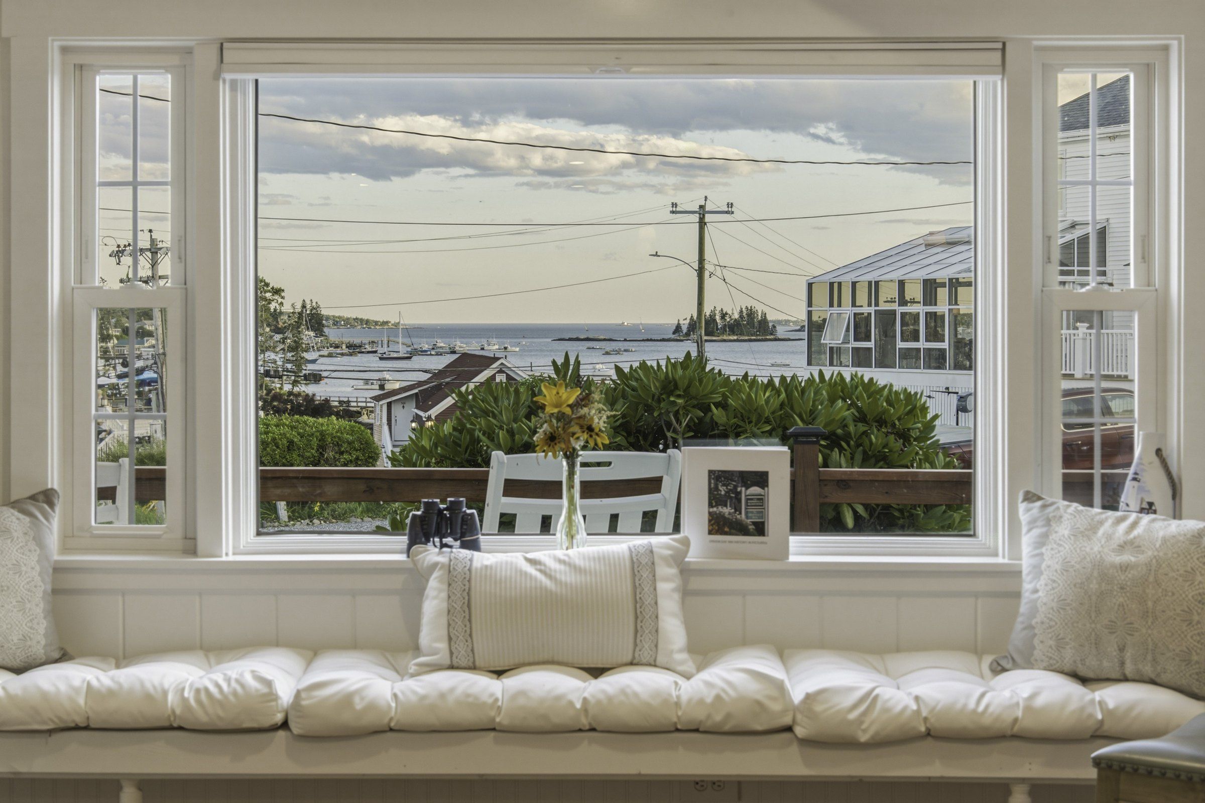 A room with a large window overlooking a marina and the sea.
