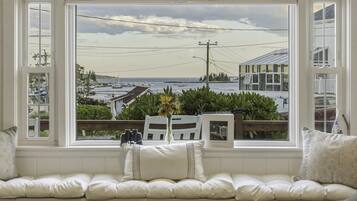 A room with a large window overlooking a marina and the sea.