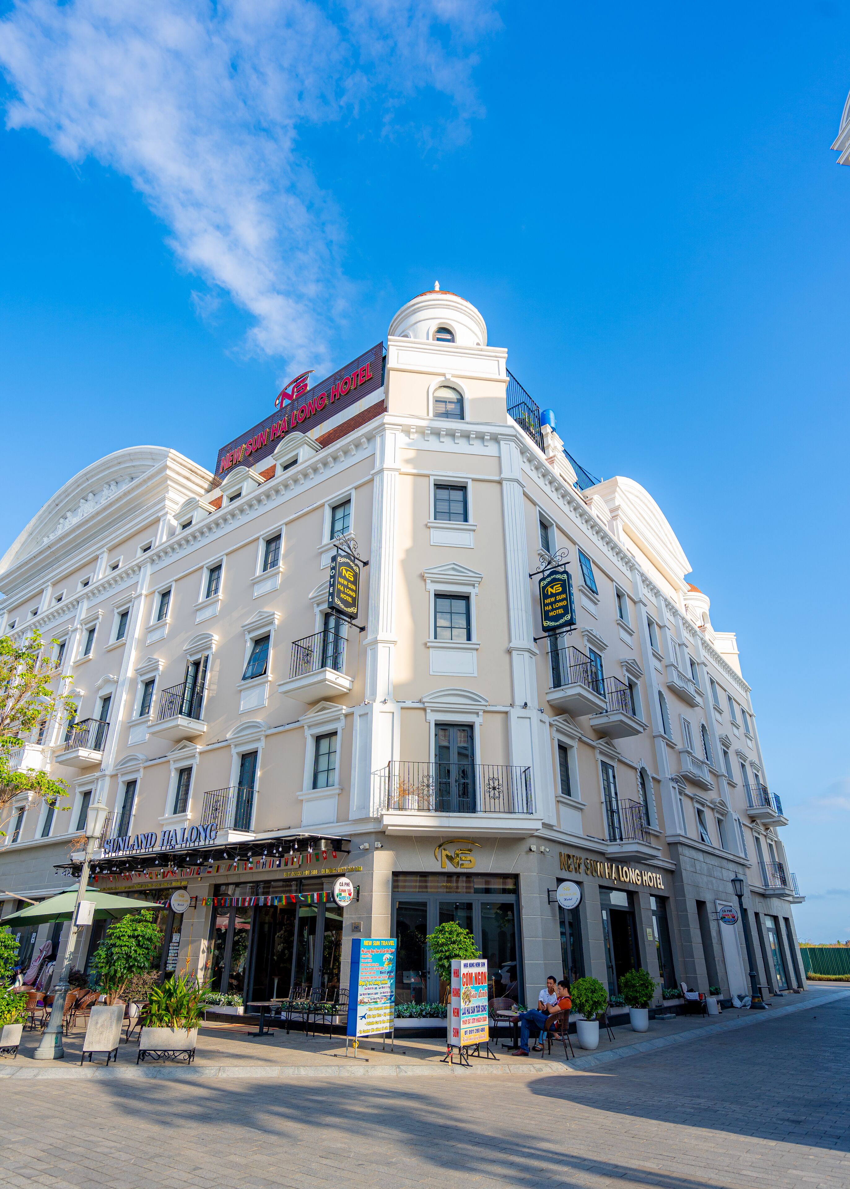 A multi-story hotel with a classic architectural design, featuring balconies and a prominent dome on the top floor.