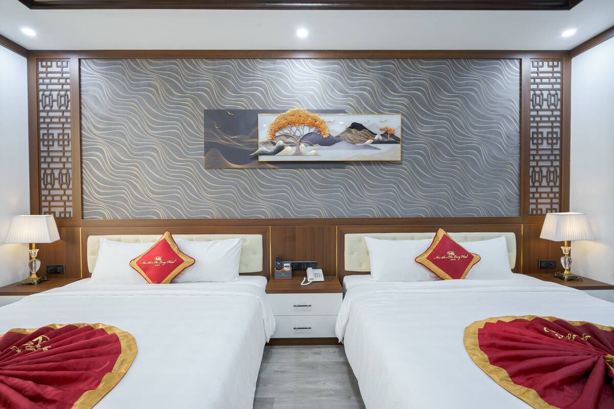A hotel room with two beds, a wall-mounted artwork, and a wooden headboard.