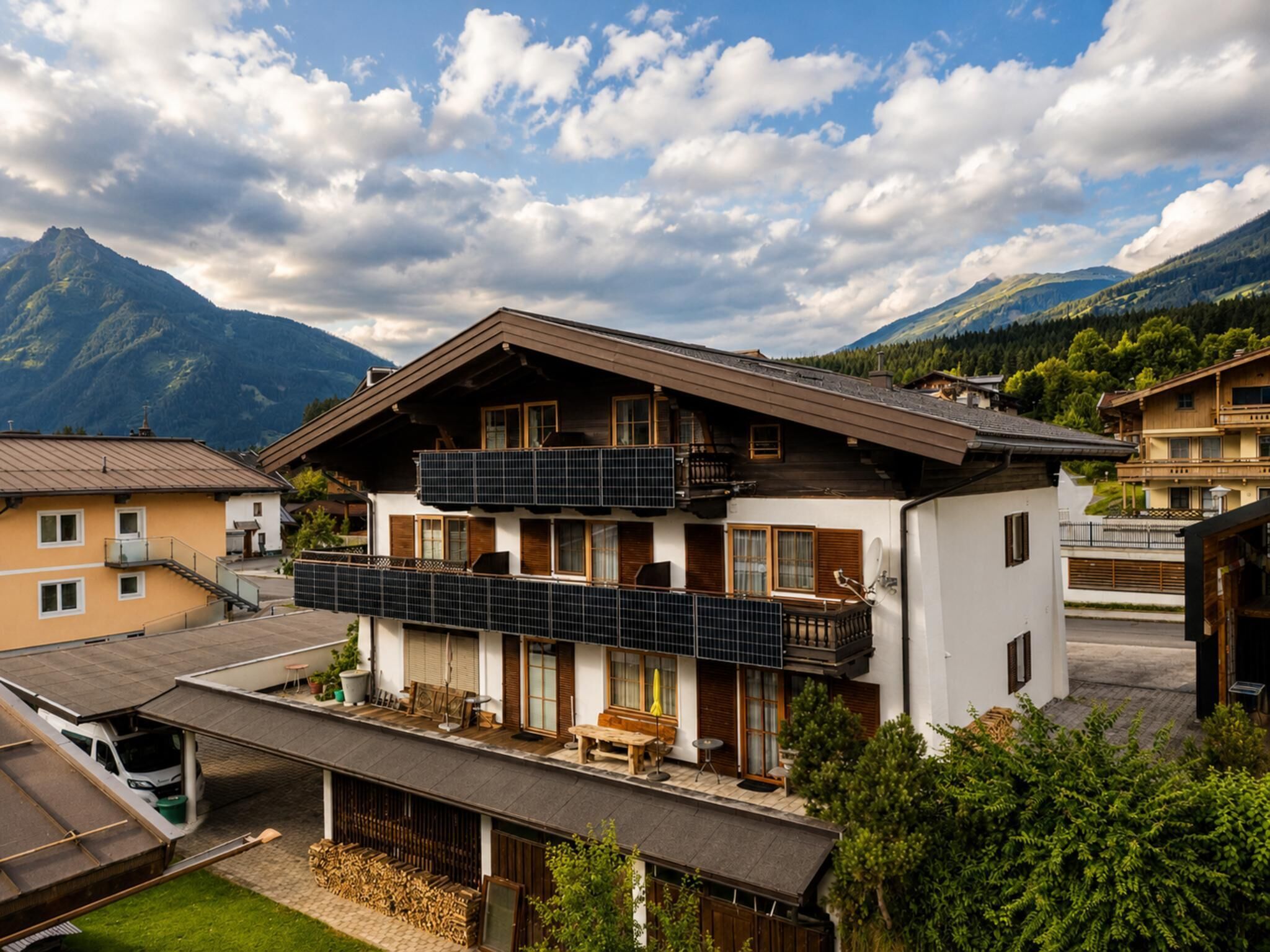 En toetages chalet med balkon, overdækket terrasse og udsigt til bjerge.