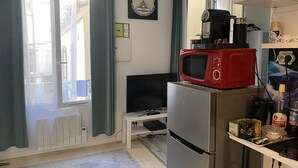 Una cucina compatta con un frigorifero, un forno a microonde e un piccolo piano di lavoro.