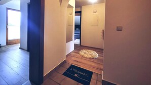 A hallway with wooden flooring, a doormat with 'Willkommen' text, and a ceiling light. - Beautiful apartment in a dream location in Finkenberg (Finkenberg)