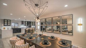 A modern kitchen with dark countertops, a central island, and pendant lighting.