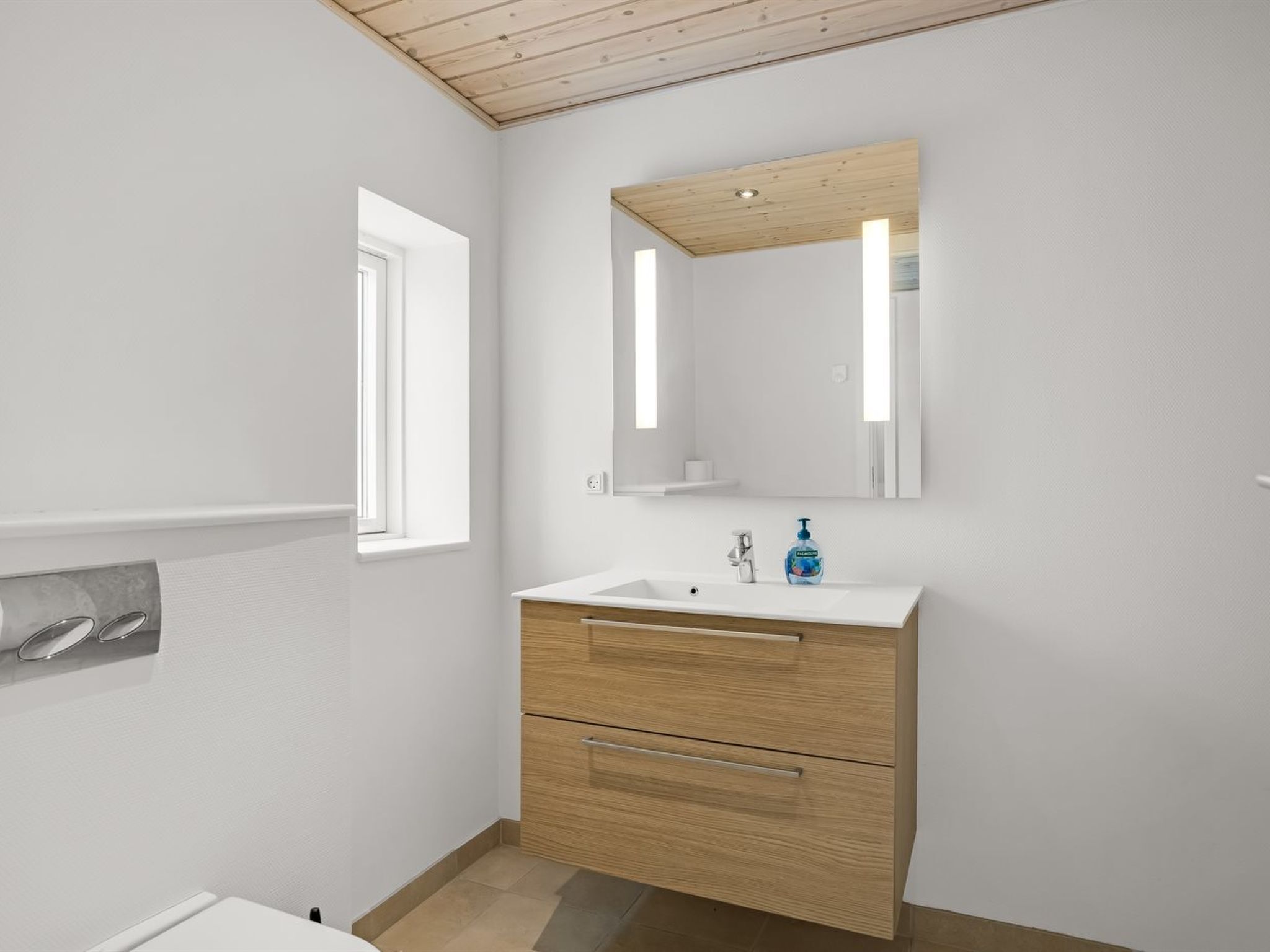 Une salle de bain moderne avec un meuble-lavabo en bois, un miroir et une fenêtre.