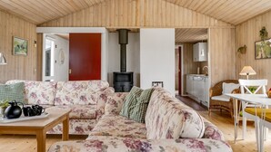 Een gezellige woonkamer met een zithoek, een tafel met kopjes en een open haard.