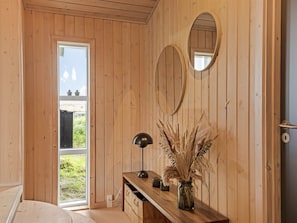 A wooden room with a desk, a lamp, and a vase with dried plants. - "Eelin" - 275m from the sea by Interhome (Løkken)