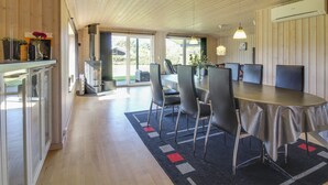 Eine moderne Küche mit Holzausstattung, einem eingebauten Herd und einem Essbereich mit großem Tisch und Stühlen.