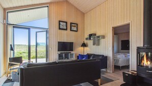 Un salon moderne avec un grand canapé, un téléviseur à écran plat et une cheminée.