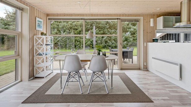 A modern kitchen with a large window, a dining area with chairs, and a view of the outdoors. - "Into" - 400m from the sea by Interhome (Løkken)