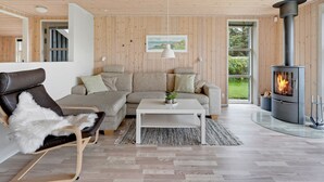 A cozy living room with a sofa, a chair, a coffee table, and a fireplace. - "Into" - 400m from the sea by Interhome (Løkken)
