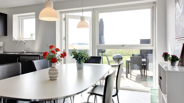Una cocina moderna con comedor, ventanas amplias y vistas al exterior.