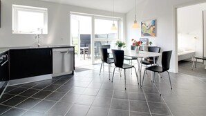 Una cocina moderna con comedor, ventanas amplias y vistas al exterior.