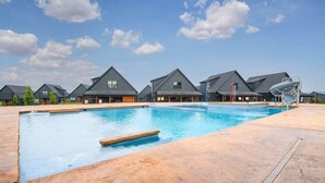 Une piscine à l’eau d’un bleu limpide, entourée d’une terrasse dallée.
