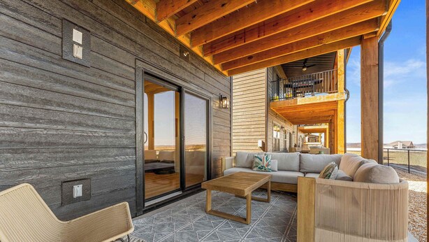 Un espace extérieur aménagé, abrité et doté d’un canapé, de chaises et d’une table basse.