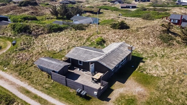 Una casa moderna con una terraza amplia y vistas al océano.