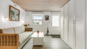 Un salon moderne avec un canapé, une table basse et des œuvres d’art accrochées au mur.