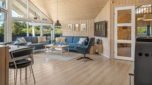 A spacious living area with a wooden ceiling, a sofa set, a coffee table, and a TV mounted on the wall. - "Federica" - 500m from the sea by Interhome (Løkken)