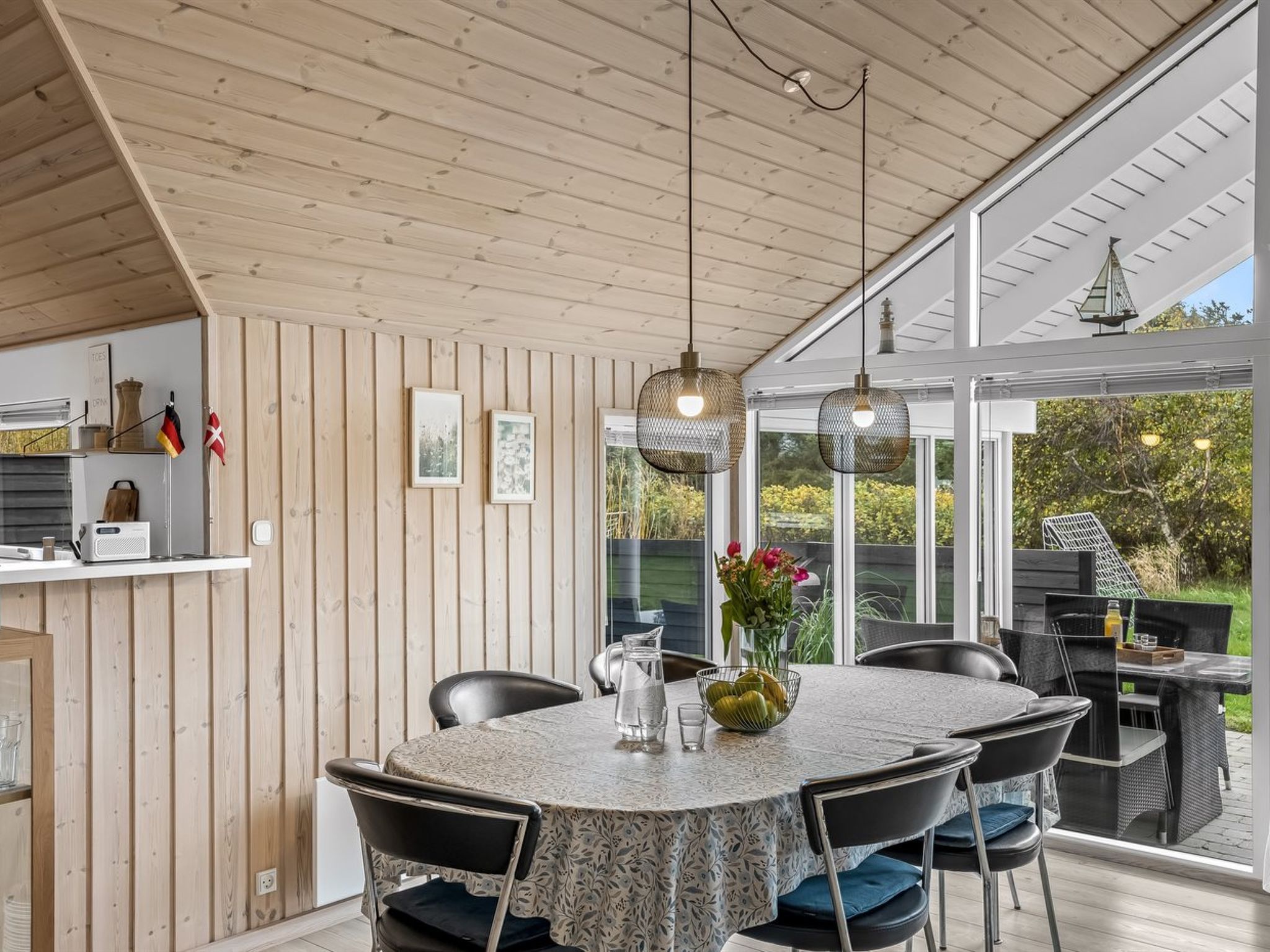 Een eetruimte met een ronde tafel, stoelen en uitzicht op de omgeving.