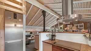 A modern kitchen with a stainless steel refrigerator, a coffee maker, and wooden cabinets.