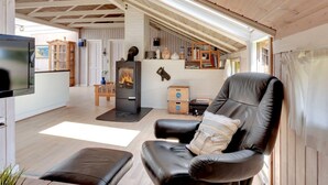Ein gemütliches Wohnzimmer mit Kamin, einer Ledersofa und einem Fernseher.