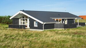 A modern two-story house with a sloped roof and large windows.