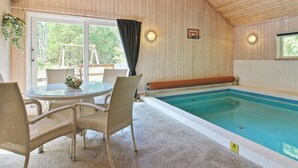 An indoor swimming pool with a glass table and wicker chairs, surrounded by wooden walls and a ceiling. - "Thordo" - 2.4km from the sea by Interhome (Rømø)