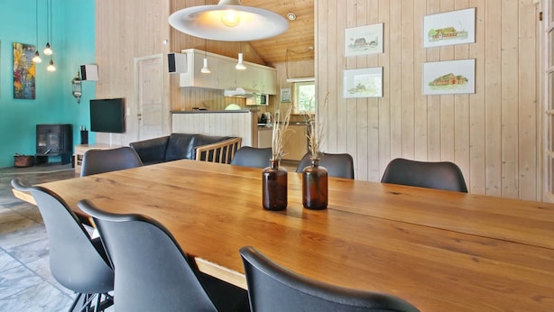 A spacious dining area with a wooden table and chairs, a hanging light fixture, and framed pictures on the wall. - "Thordo" - 2.4km from the sea by Interhome (Rømø)